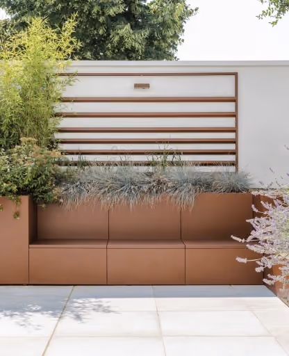 Sistema modulare Modularte in acciaio Corten con fioriere integrate, seduta outdoor e pannello frangivista a lamine orizzontali coordinato.